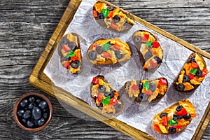 Crostini with pieces of fish stewed in tomato sauce