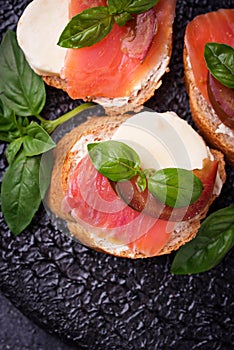 Crostini with salmon, mozarella, tomato and basil