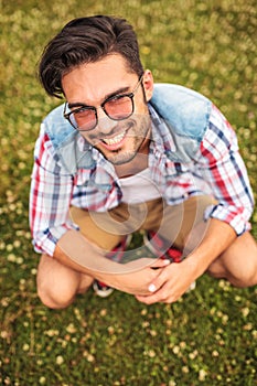 Crouched young man in a grass field photo