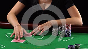 Croupier is dealing cards at a casino. Poker player looking at her cards. Concept of gambling, risk, luck, win, fun, and