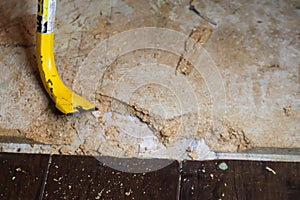 Crowbar on subfloor with chuncks out of it