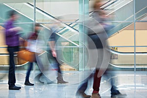 Crowd of Blurred Young People Walking Along Modern Corridor