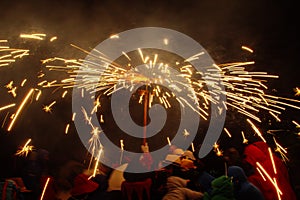 Crowd celebrating with fireworks display at night photo