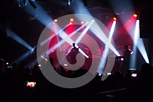 Crowd at concert and blurred stage lights .