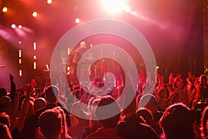 Crowd dancing to music during concert in neon lights