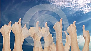 Crowd group simultaneously raising thumb up on blue sky background