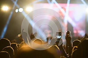 Crowd hands in the air at the concert smartphone filming