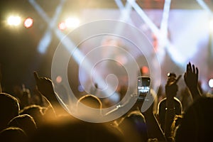 Crowd hands in the air at the concert smartphone filming