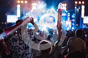 Crowd of hands up concert stage lights and people fan audience silhouette raising hands in the music festival rear view with