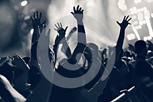 Crowd at a music concert, audience raising hands up, toned