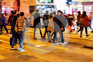 Crowd of people crossing a street at night