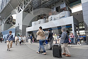 Crowd of people at the main entrance to Kyoto Station building, the major railway station and transportation hub in Kyoto, Japan.