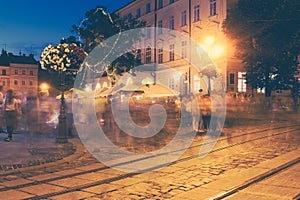 A crowd of people moving on the old European city night street