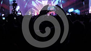 Crowd people at music concert . Cheering crowd in front of bright colorful stage lights. lifestyle silhouettes of