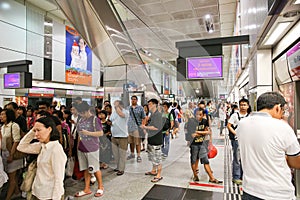 Crowd of people in Singapore subway waiting for the train.