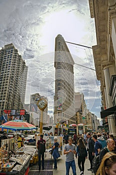 Crowd of people visiting small market on Flatiron Building Plaza in front of one of the most popular landmarks in New York City