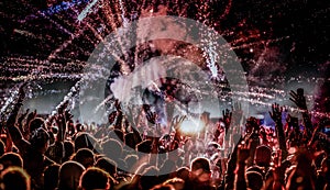 crowd with raised hands at concert festival banner