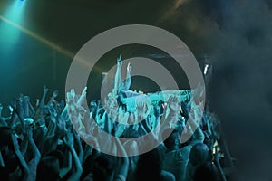 Crowd surfing. A stage diver being carried across the audience at a rock concert.