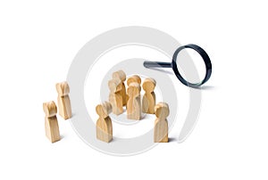 A crowd of wooden human figure stands near a magnifying glass on a white background. The concept of the search for people and