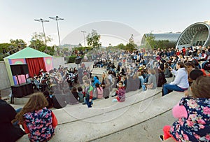 Crowd of young people sitting on a concert of an orchestra at park Rike during festival in Tbilisi