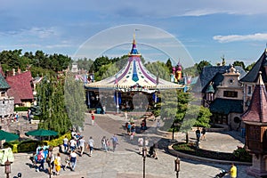 a crowded amusement and shopping area on a sunny day and blue sky
