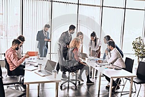 Crowded office room with hardworking people photo