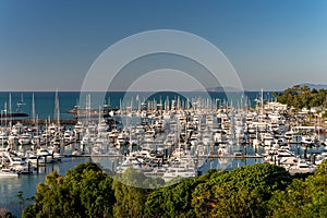 Crowded port of Airlie beach marina with anchored boats and yachts captured at sunset