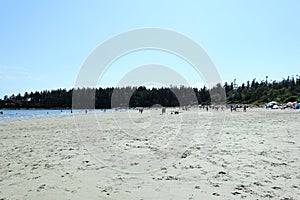 A crowded sandy beach full of locals and tourists on a beautiful sunny day in Tribune Bay, on Hornby island, British Columbia, Can