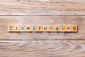 CROWDFUNDING word written on wood block. CROWDFUNDING text on wooden table for your desing, concept