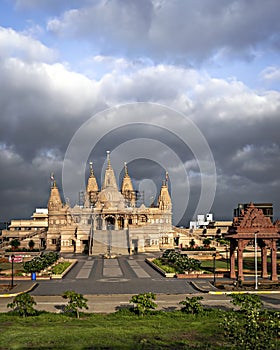 Crowdless Swaminarayan temple on a clear sunny day with clouds background in Ambegaon, Pune, Maharashtra, India photo