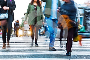 Crowds of people in motion blur crossing a city street