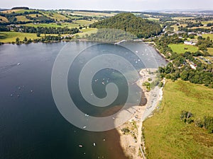 Crowds of people on a small lakeside beach in the middle of summer (Ullswater, Lake District, England