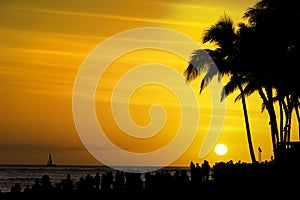 Crowds of tourists gather to watch the sunset on Waikiki Beach Honolulu Oahu Hawaii USA