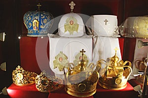 Crown and priests hats on a red background