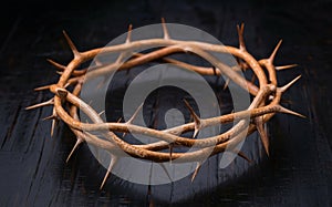 Crown of thorns on black wooden background. Christian symbol