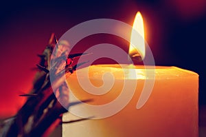 The crown of thorns of Jesus Christ and a lit candle photo