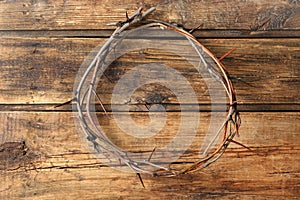 Crown of thorns on wooden background, top view. Easter attribute