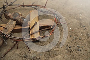 Crown of thorns, wooden cross and hammer with nails on ground, space for text. Easter attributes