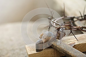 Crown of thorns, wooden plank and hammer on grey background, closeup. Easter attributes