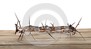 Crown of thorns on wooden table against white background, space for text. Easter attribute