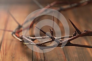 Crown of thorns on wooden table, closeup. Easter attribute