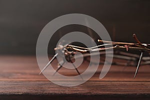 Crown of thorns on wooden table  closeup with space for text. Easter attribute