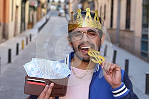 Crowned young guy with full wallet