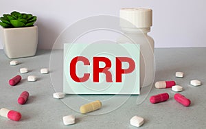 CRP analysis on a white business card. Jar of pills