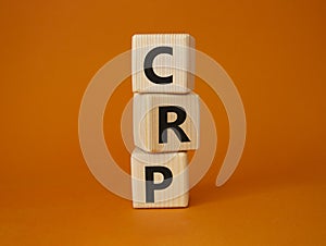 CRP - C-Reactive Protein Test symbol. Wooden cubes with word CRP. Beautiful orange background. Medical and C-Reactive Protein Test