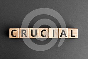 Crucial - word from wooden blocks with letters