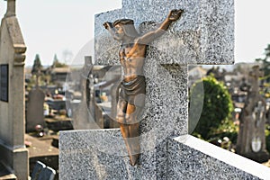 Crucified Jesus Christ on a cross on a grave in a cemetery
