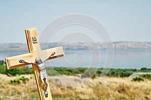 A crucifix with background of the Sea of Galilee and Capernaum viewed from the Church Of The Beatitudes, Israel