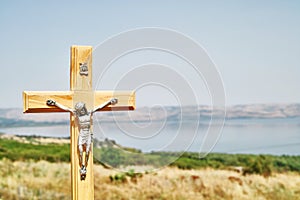 A crucifix with background of the Sea of Galilee and Capernaum viewed from the Church Of The Beatitudes, Israel