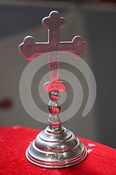 Crucifix in the foreground inside a church, silver cross inside the church